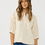 Woman wearing a beige blouse and blue jeans on a white background