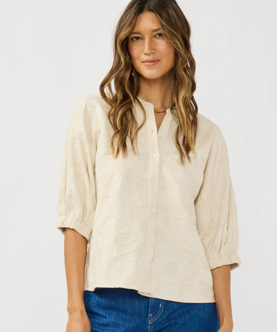 Woman wearing a beige blouse and blue jeans on a white background