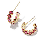 Gold hoop earrings with red gemstones on a white background