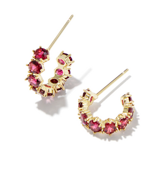 Gold hoop earrings with red gemstones on a white background