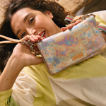 Woman holding a colorful handbag with a visible brand logo