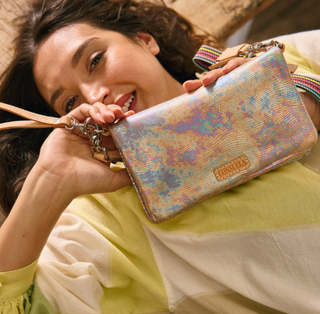 Woman holding a colorful handbag with a visible brand logo
