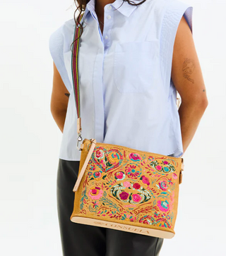 Person wearing a colorful embroidered bag with a white background