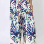 Colorful tropical print pants worn by a person on a white background