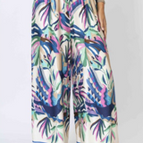 Colorful tropical print pants worn by a person on a white background
