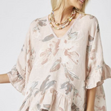 Woman wearing a floral blouse with ruffled sleeves on a white background
