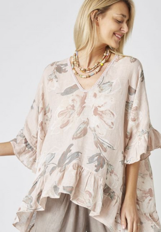 Woman wearing a floral blouse with ruffled sleeves on a white background