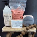 Collection of 'Grace' skincare products on a wooden stand with a dark background