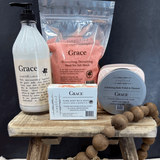 Collection of 'Grace' skincare products on a wooden stand with a dark background