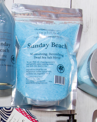 Package of 'Sunday Beach' Dead Sea Salt blend with a bottle and other products in the background.