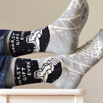 Gray socks with black and white designs on a white chair