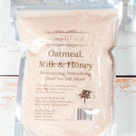 Bag of Oatmeal, Milk & Honey Dead Sea Salt blend with 'simplified' branding on a wooden surface.