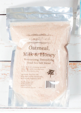 Bag of Oatmeal, Milk & Honey Dead Sea Salt blend with 'simplified' branding on a wooden surface.