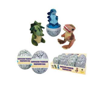 Dinosaur surprise eggs and plush dinosaur toys on a plain white background. The set includes two gray cracked-egg surprise eggs with paper bands, a box of multiple eggs, and three plush dinosaur figures emerging from or displayed with the eggs: a green dinosaur, a blue dinosaur on a pedestal, and a brown dinosaur with red teeth.
