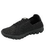A black woven slip-on shoe with a textured, basket-weave upper and a chunky, treaded sole, shown from a three-quarters angle on a white background.