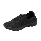 A black slip-on woven shoe with a textured knit upper, black laces, and a chunky black sole, shown from a three-quarters angle on a white background.