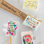 Set of colorful toothbrush covers with motivational phrases on a marble surface.