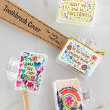Set of colorful toothbrush covers with motivational phrases on a marble surface.