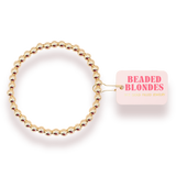 Gold beaded hair tie with 'Beaded Blondes' packaging on a white background