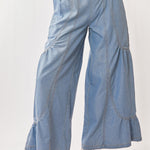 Light blue denim wide-leg pants worn by a person on a white background