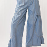Light blue denim wide-leg pants worn by a person on a white background