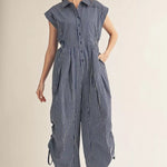 Woman wearing a blue and white striped jumpsuit on a beige background