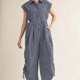 Woman wearing a blue and white striped jumpsuit on a beige background