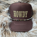 Brown cap with 'HOWDY' text on a textured surface