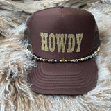 Brown cap with 'HOWDY' text on a textured surface