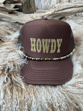 Brown cap with 'HOWDY' text on a textured surface