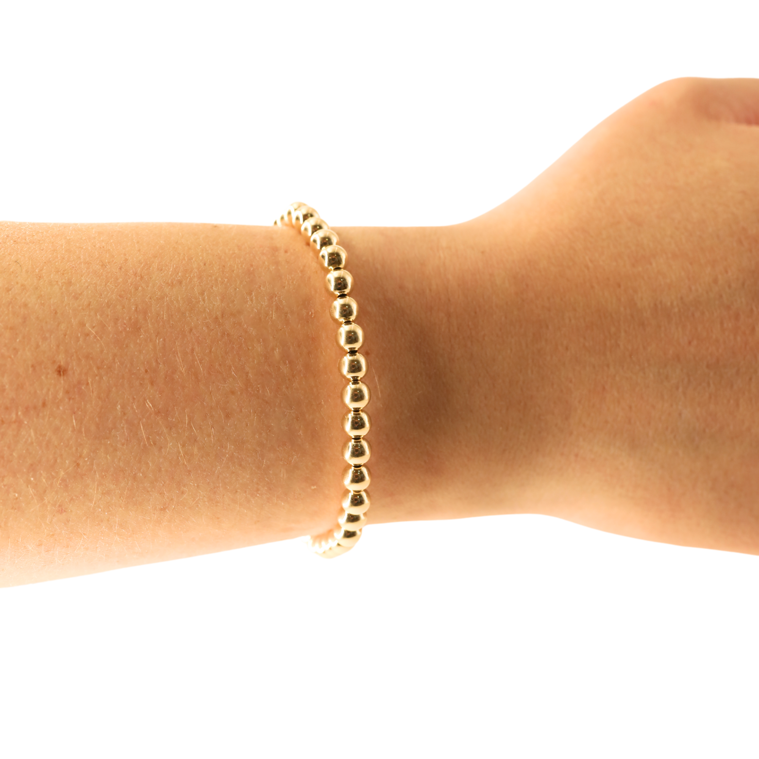 Gold bracelet on a wrist against a white background