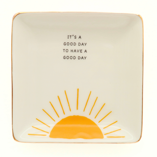 Decorative plate with sun design and text 'It's a good day to have a good day' on a white background