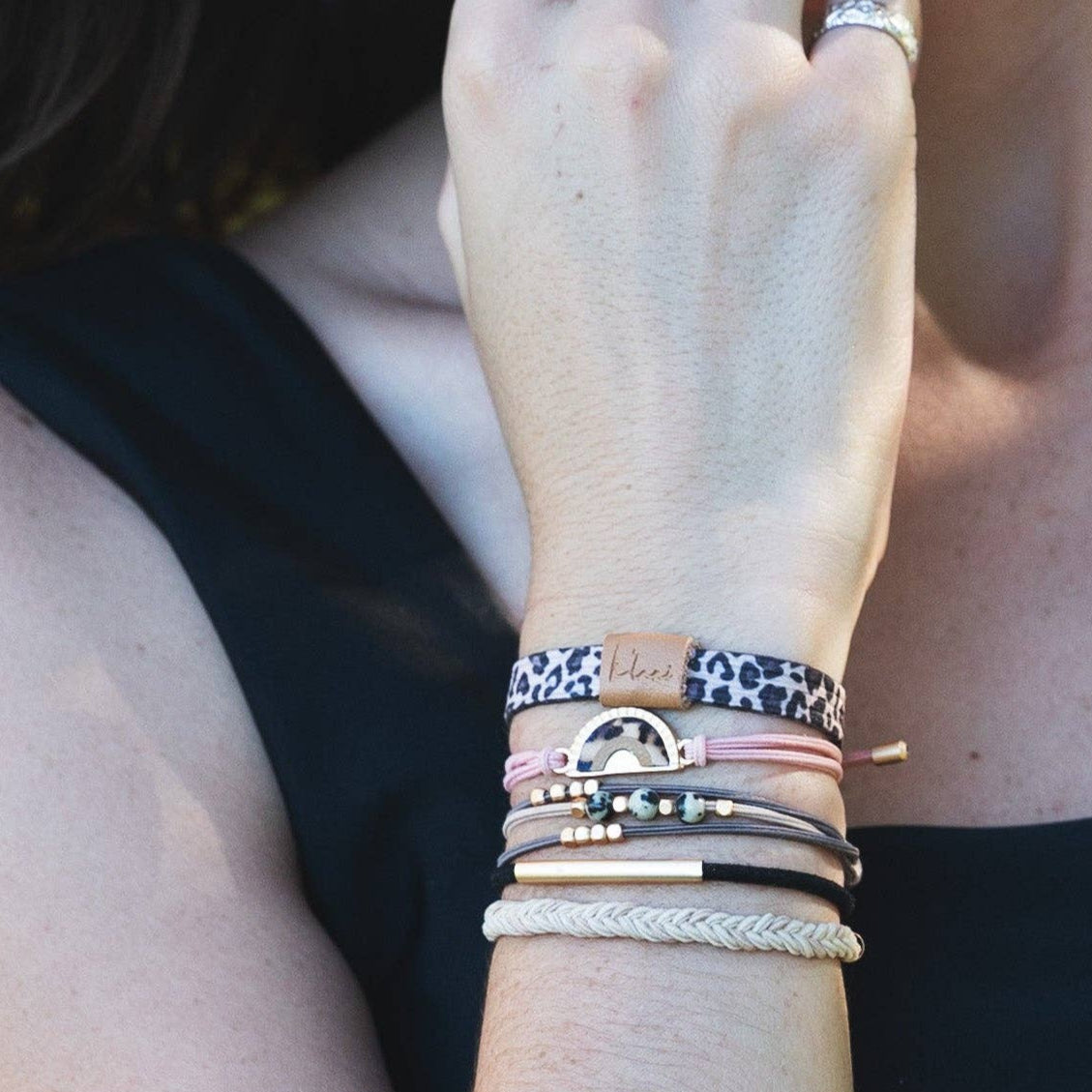 Close-up of a wrist wearing multiple bracelets with a blurred background