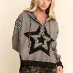 Woman wearing a gray sweater with star design and camouflage pants on a beige background