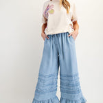 light blue pant with ruffle and gril with hat and cream tee and sneakers