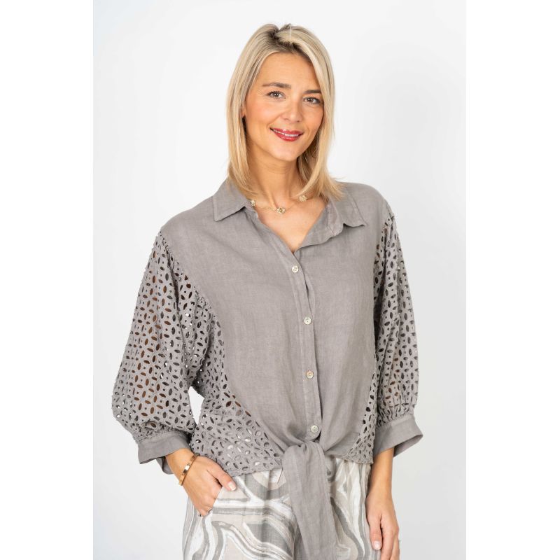 Woman wearing a gray shirt with lace details on a white background