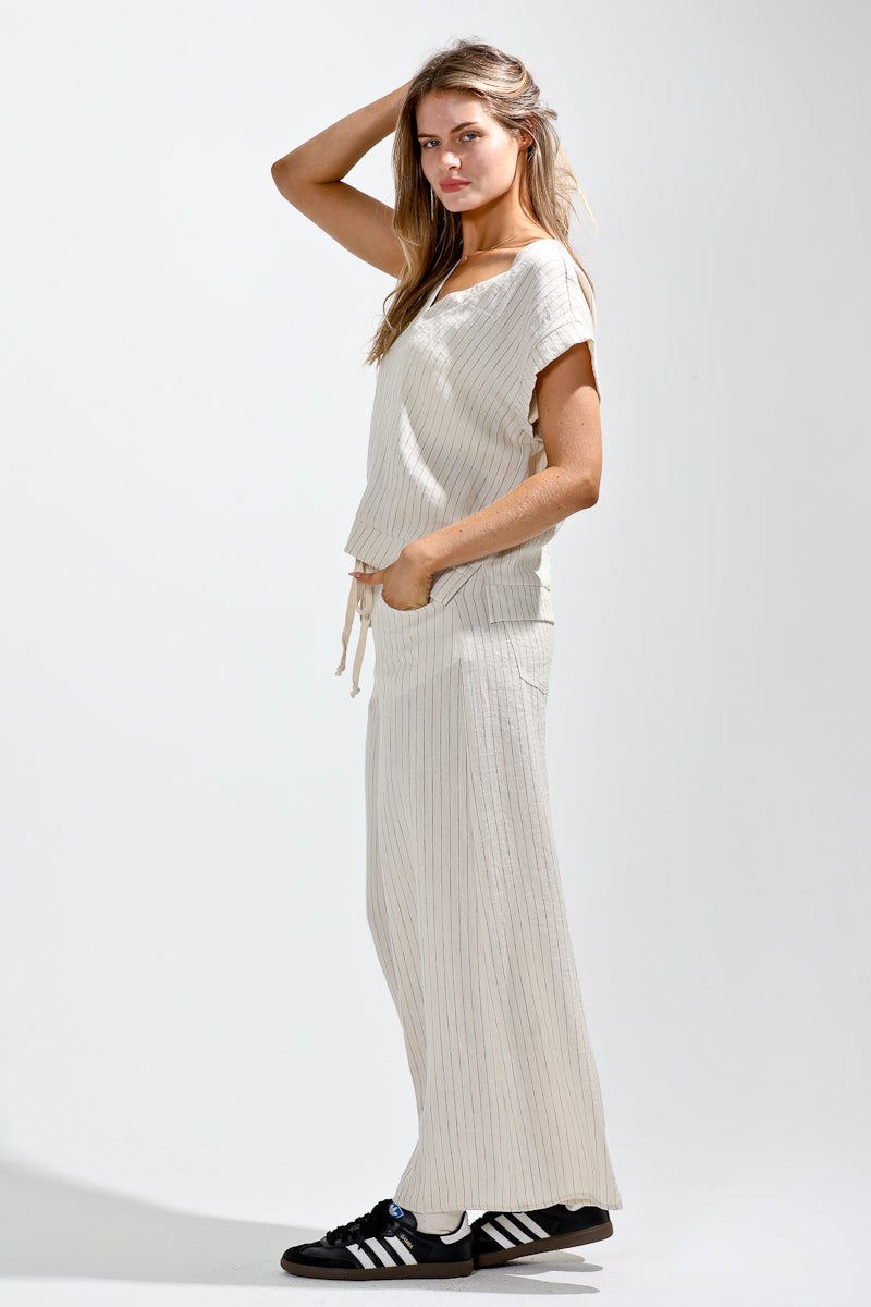 Woman wearing a white dress with black Adidas shoes on a light gray background