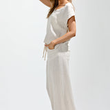 Woman wearing a white dress with black Adidas shoes on a light gray background