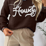 Person wearing a brown sweater with 'Howdy' text and beige shorts against a white background