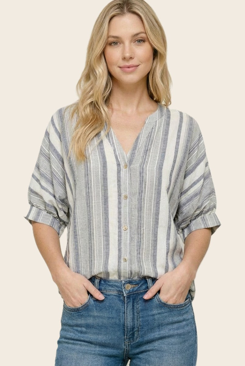 Woman wearing a striped shirt and jeans on a beige background