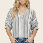 Woman wearing a striped shirt and jeans on a beige background
