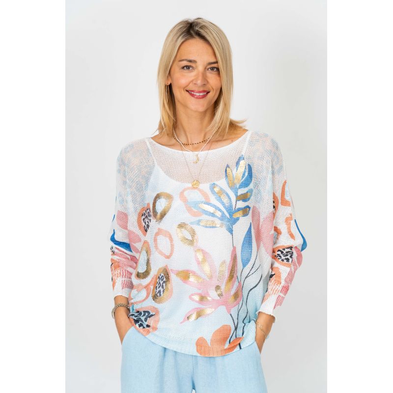 Woman wearing a colorful floral sweater against a plain background