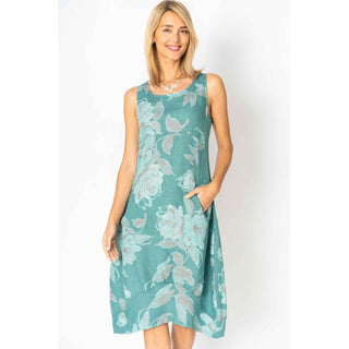 Woman wearing a teal floral dress against a white background