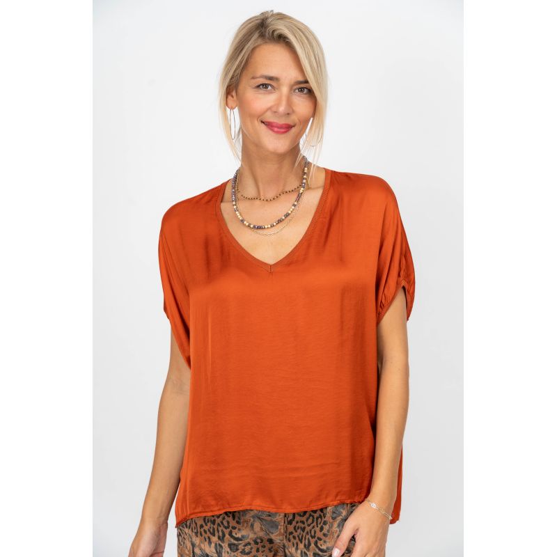 Woman wearing an orange top on a white background
