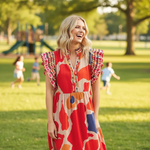 Blonde model wearing geo print midi dress laughing in park with children