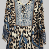 Leopard print dress with blue accents on a hanger against a gray background