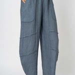 Blue denim pants worn by a person on a white background