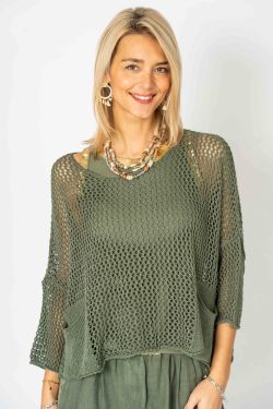 Woman wearing a green knit top and skirt set against a white background