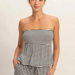 Woman wearing a black and white striped dress against a plain background