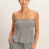 Woman wearing a black and white striped dress against a plain background
